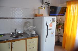 a kitchen with a white refrigerator and a sink at TAID in Esquel