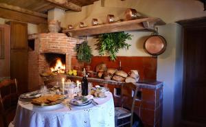 a kitchen with a table with food and a fireplace at Au coeur du Village de Lucciana in Lucciana