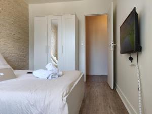 een slaapkamer met een bed en een flatscreen-tv bij Appart'HomeCity - Rouen Grand Prieuré in Rouen