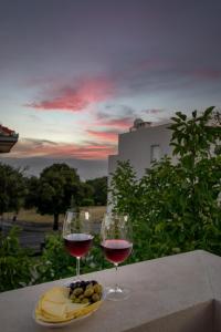 two glasses of wine and a plate of fruit on a table at Luxury apartment Mirage Split in Split