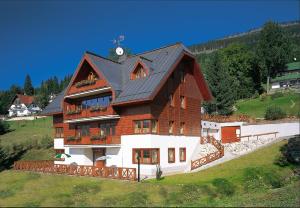 a large house on top of a hill at Třílůžkový pokoj Pension Kubů in Špindlerův Mlýn