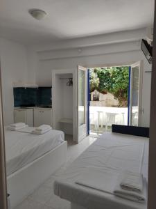 a bedroom with two beds and a view of a patio at Superior Beach in Pefkohori