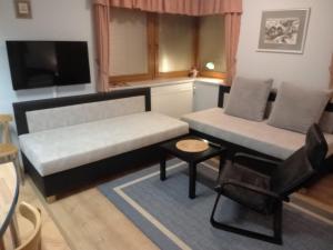 uma sala de estar com um sofá e uma mesa em Pension Kubů Apartment 4 samostatný byt s kuchyní em Spindleruv Mlyn