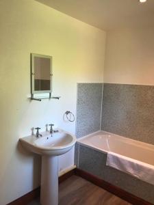 a bathroom with a sink and a bath tub at Maberry Cottage in Bargrennan