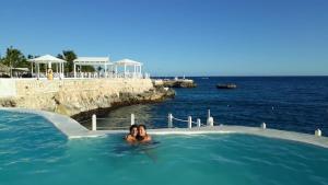 una donna in una vasca idromassaggio in riva all'oceano di private apartment estudio ocean view solo adultos a La Laguna