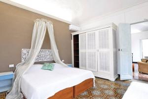 a bedroom with a white bed with a canopy at Appartamento della piazza in Chiavari