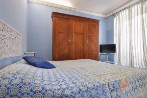 a blue bedroom with a bed and a wooden cabinet at Appartamento della piazza in Chiavari +7 photos