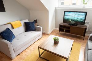 a living room with a couch and a tv at Modern Merchant City Apartment by George Square in Glasgow