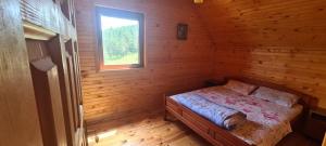 um quarto com uma cama num chalé de madeira em Guest house STAŠA,Žabljak em Žabljak