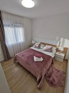sypialnia z dużym łóżkiem i fioletowym kocem w obiekcie Apartments Ivana w mieście Sveti Filip i Jakov