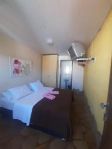 ein Hotelzimmer mit einem Bett mit rosa Papier darauf in der Unterkunft Pousada Aliens in São Thomé das Letras