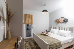 una camera bianca con letto e tavolo di Areti Seaview Residence a Rethymno
