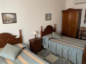 a bedroom with a bed and a dresser at Hostal Las Palomas in La Calzada de Calatrava