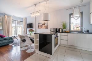 a kitchen with white cabinets and a black counter top at Apartamenty Gdansk EU - Waterlane - Apartament Marina - Old Town in Gdańsk