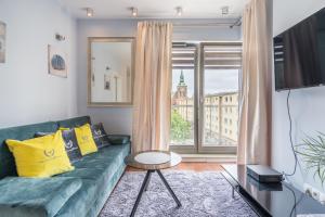 uma sala de estar com um sofá verde e uma janela em Apartamenty Gdansk EU - Waterlane - Apartament Marina - Old Town em Gdansk