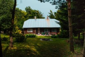 a log cabin with a tin roof in a yard at Ptasi Śpiew in Futoma