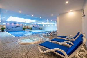 uma piscina com espreguiçadeiras e uma banheira de hidromassagem em Apartamenty Gdansk EU - Waterlane - Apartament Marina - Old Town em Gdansk