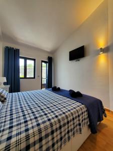 Un dormitorio con una cama con una manta de cuadros azul y blanco en Charming Bellagio SUN CLUB, en San Bartolomé