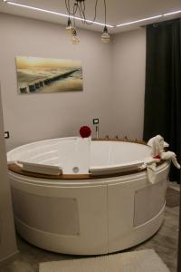 una vasca da bagno bianca in una stanza con un dipinto di balai suite a Porto Torres