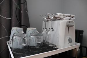 a white toaster sitting on a shelf with glasses at Casa Linda Victoriaville in Princeville