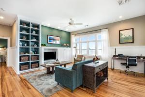 uma sala de estar com um sofá azul e uma televisão em Eagle Cottages at Gulf State Park em Gulf Shores