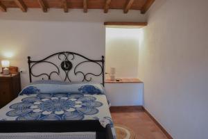 a bedroom with a bed with a blue comforter at ELBA Borgo di Latrano in Magazzini