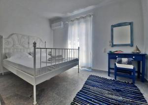 een slaapkamer met een bed, een spiegel en een stoel bij BLUE IN NAXOS in Naxos Chora