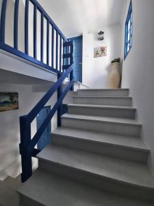 a staircase with a blue hand rail and a vase at BLUE IN NAXOS in Naxos Chora