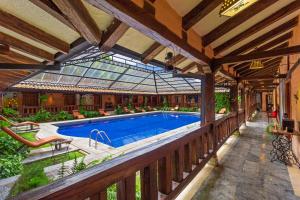 a swimming pool in a house with a glass roof at Samari Spa Resort in Baños