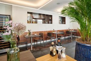 a restaurant with tables and chairs and bottles of wine at Auberge La Croix-Blanche in Gingins