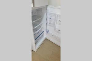 an empty refrigerator with its door open in a room at Luxury apartment at Jardin Carthage Tunis in Tunis