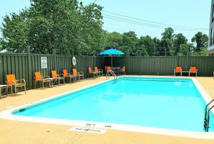 a swimming pool with chairs and a table and an umbrella at Holiday Inn Express - Lorton, an IHG Hotel in Lorton