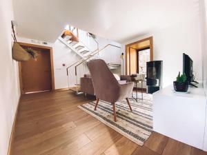 a living room with a chair and a staircase at Casa Azevedos in Ponte da Barca