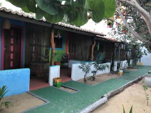 uma casa com um relvado verde em frente em Pousada o Mineiro Central em Galinhos