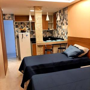 um quarto com uma cama e uma cozinha com um balcão em Apartamento Mania em Vitória