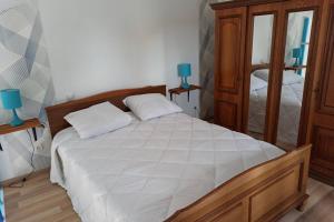 een slaapkamer met een groot bed en een spiegel bij Gite La Floiracaise in Floirac