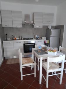 uma cozinha com uma mesa branca e electrodomésticos brancos em Il Sogno di Bea em Terni