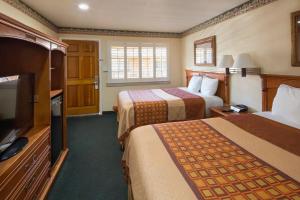 a hotel room with two beds and a flat screen tv at Geary Parkway Motel in San Francisco