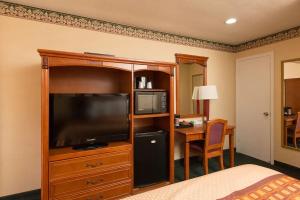 Habitación de hotel con cama, TV y escritorio. en Geary Parkway Motel en San Francisco