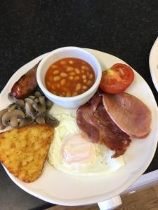 a plate of breakfast food with eggs bacon beans and toast at Southville Guest House in Weymouth