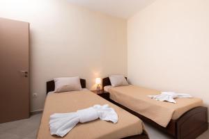 a room with two beds with white towels on them at Afroditi´s House in Ipsos