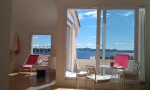 a room with a table and chairs and a large window at Mala vila Punta Skala in Petrcane