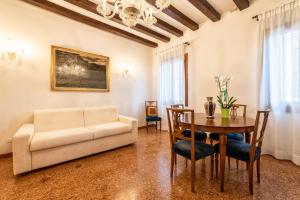 a living room with a couch and a table at Casanova Fenice - Canal View in Venice