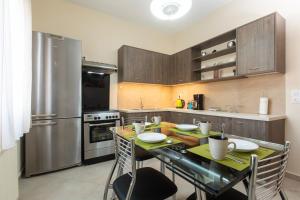 a kitchen with a table with chairs and a refrigerator at Afroditi´s House in Ipsos