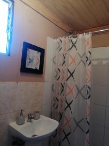 a bathroom with a sink and a shower curtain at La Casa Blanca in San Pedro de Atacama