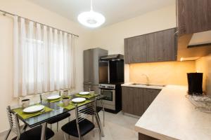 a kitchen with a table with chairs and a counter top at Afroditi´s House in Ipsos +18 photos