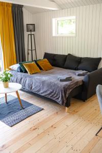 ein Wohnzimmer mit einem Bett und einem Tisch in der Unterkunft Mežmadaras in Kuldīga