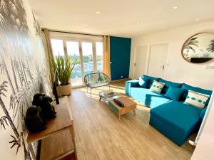 uma sala de estar com um sofá azul e uma mesa em Evasion dépaysante en bord de Garonne em Toulouse