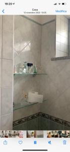 a bathroom with a sink and shelves on the wall at Residence San Pietro Book sharing in Nola +34 photos