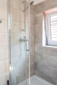 y baño con ducha y puerta de cristal. en Apartament Piastowska, en Olsztyn